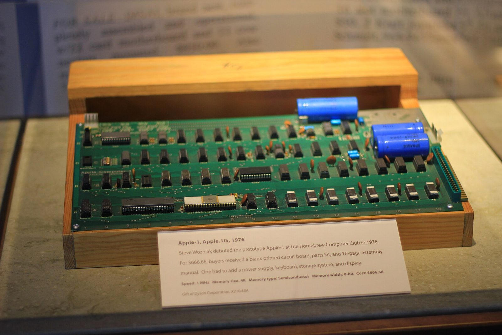 An Apple-1 circuit board mounted in a wooden case in a museum vitrine