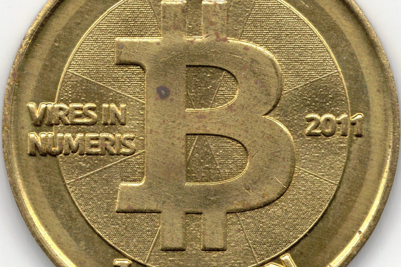 The face of a brass Casascius physical bitcoin token dated 2011