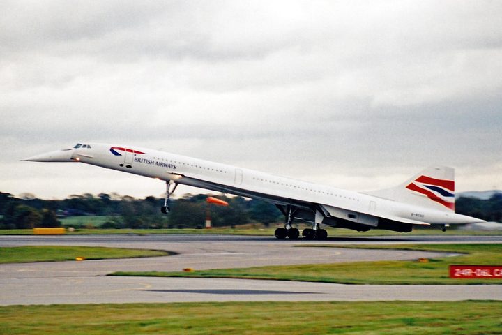 A British Airways Concorde low over the airfield with its landing gear down and nose drooped