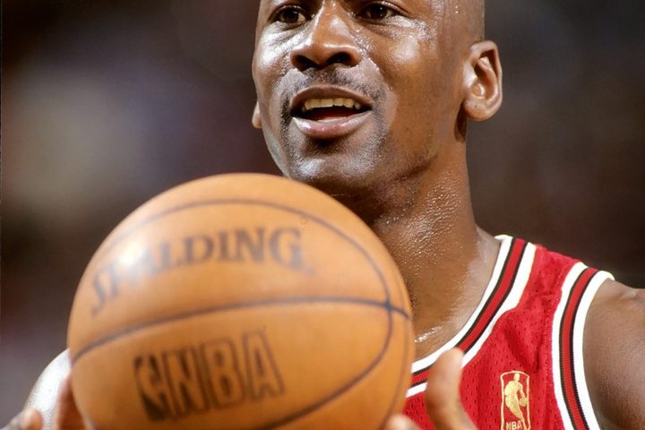 Michael Jordan in a Chicago Bulls jersey holding a basketball