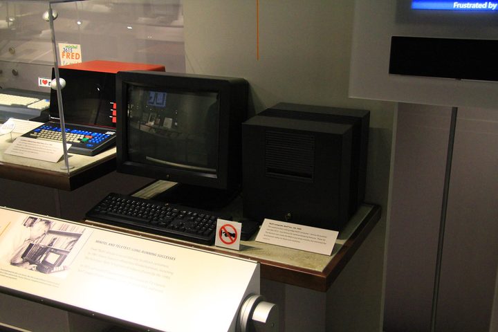 A black NeXT cube workstation with its monitor and keyboard in a museum display